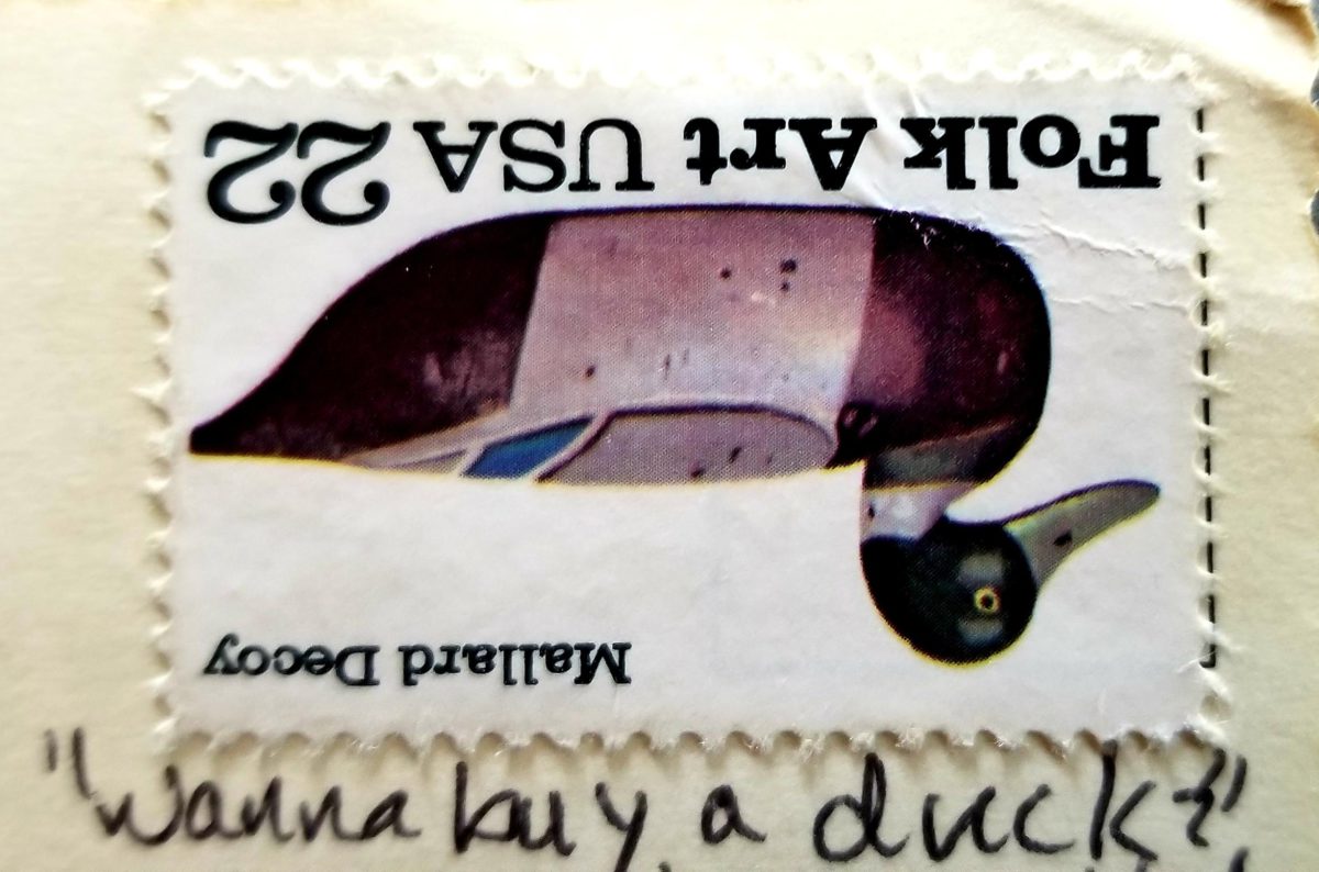 Photo of upside down 22 cent stamp with a duck on it and the words Folk Art USA and the hand-written words "Wanna buy a duck"?