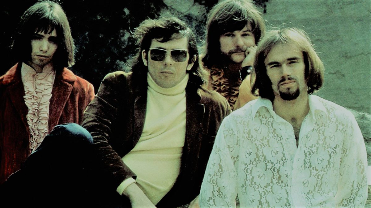 Photo of the four members of Iron Butterfly sitting on grass