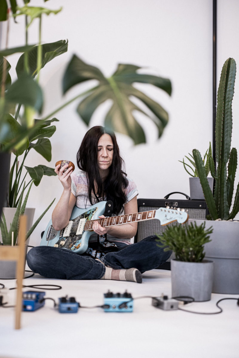 Juleah Sitting on Floor with light blue guitar and pedals