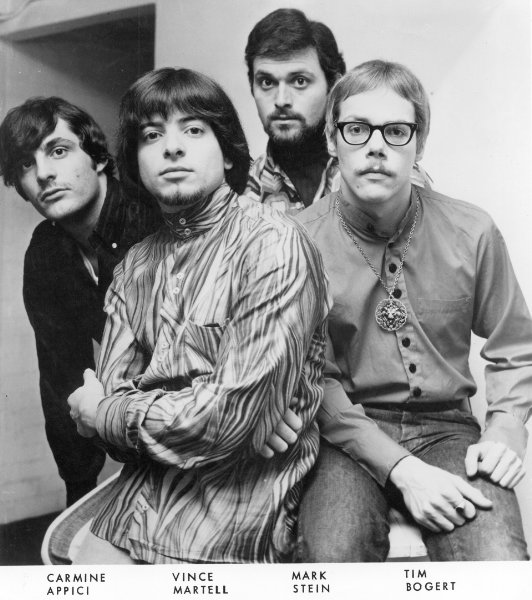 Black and white publicity photo of Vanilla Fudge featuring all four members close together with names at bottom