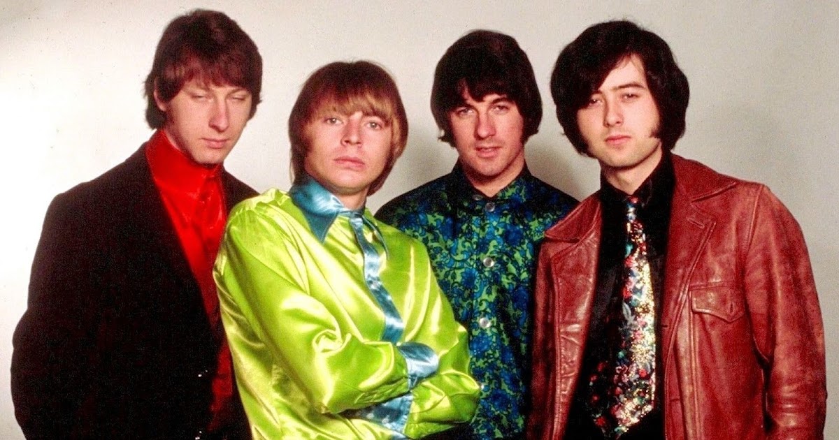 The four members of The Yardbirds, including Jimmy Page, standing against a backdrop wearing bright, flashy clothes