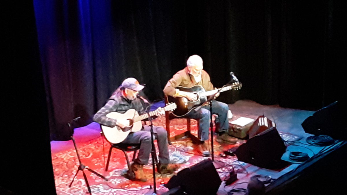 Jorma Kaukonen & John Hurlbut performing on stage with guitars and black curtains around them
