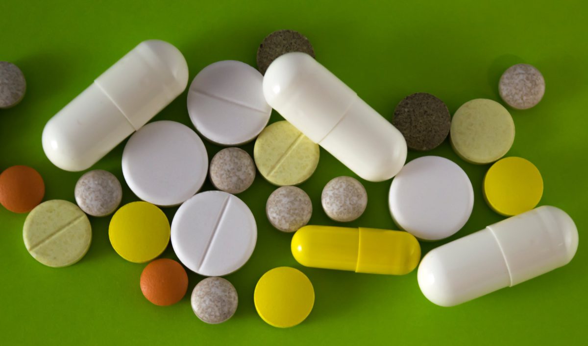 Overhead shot of various Benzodiazipines in many shapes and sizes on green countertop