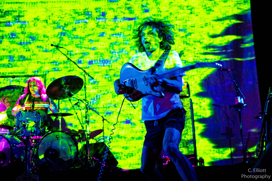 King Gizzard and the Lizard Wizard performing live with green imagery projected on them and on the background