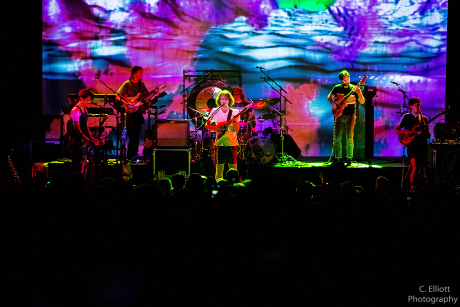 King Gizzard and the Lizard Wizard performing live with intense psychedelic patterns projected on them and the background