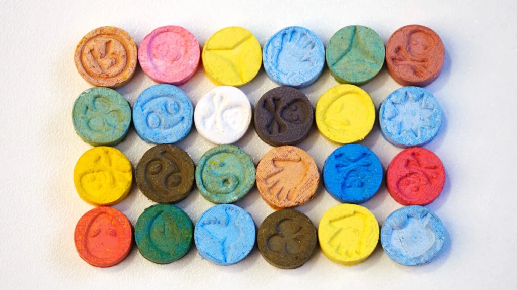 Brightly colored MDMA tablets in neat rows
