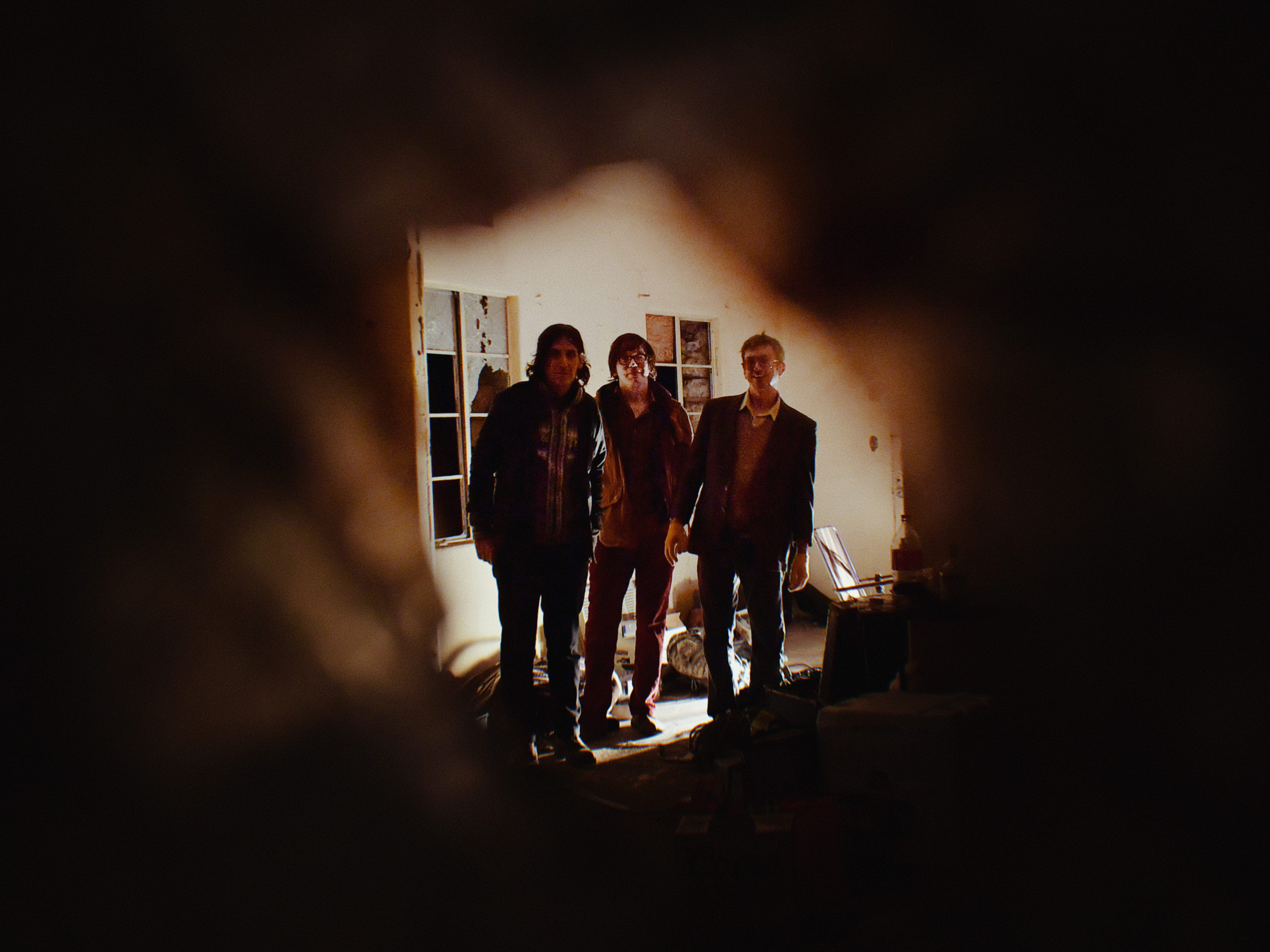 Dead Meadow band members posing for photo looking out from a dark room
