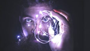 Close-up of Bearded Man Holding Hand Up with electricity coming from his fingers