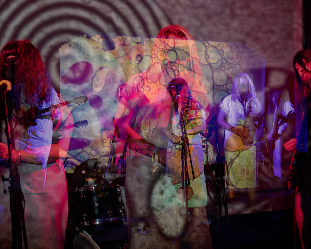 Double-exposed image of band performing with abstract image overlaid