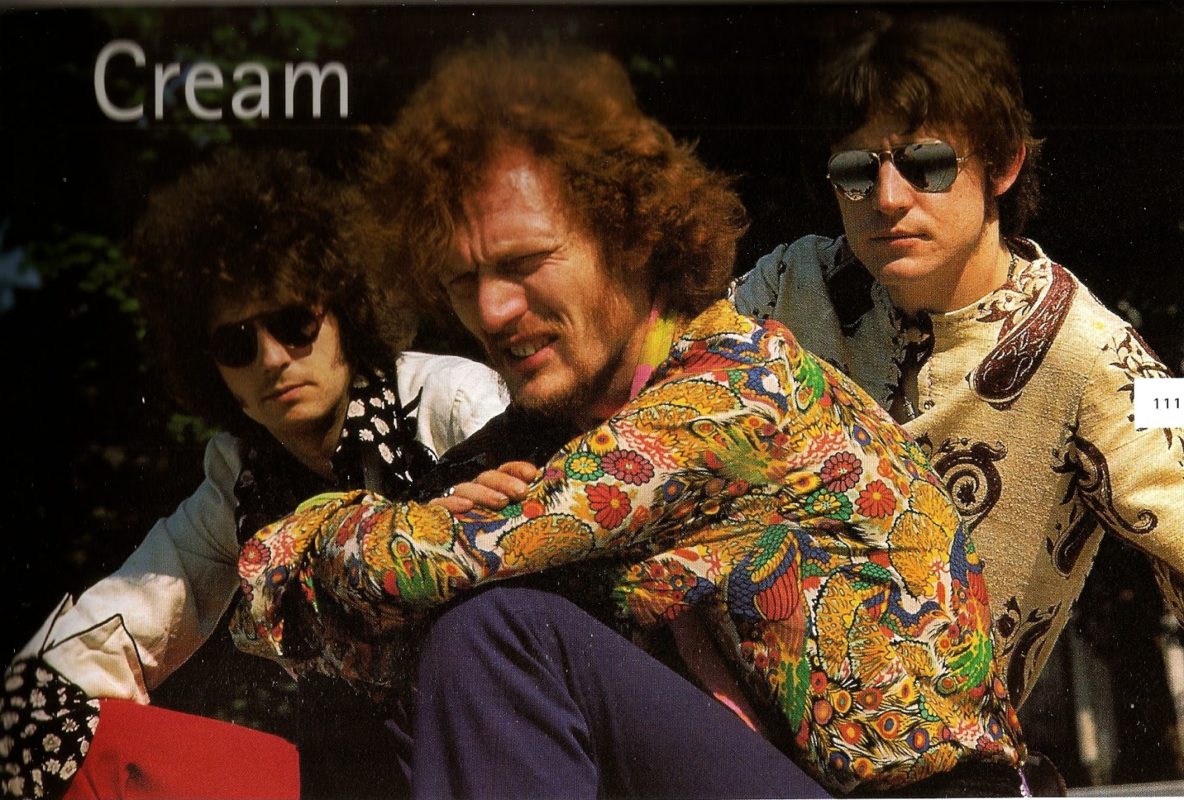 Cream members sitting with Ginger Baker in paisley shirt in foreground