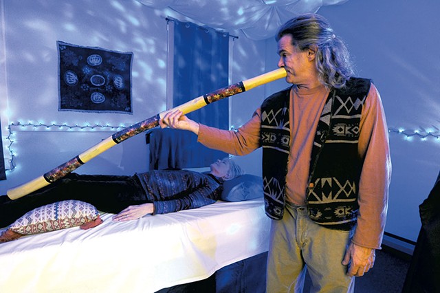 Man playing didgeridoo to calm client