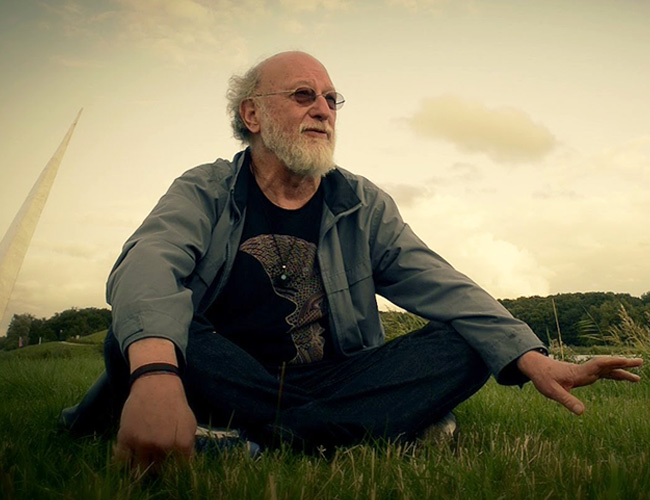Dennis McKenna sitting on green grass