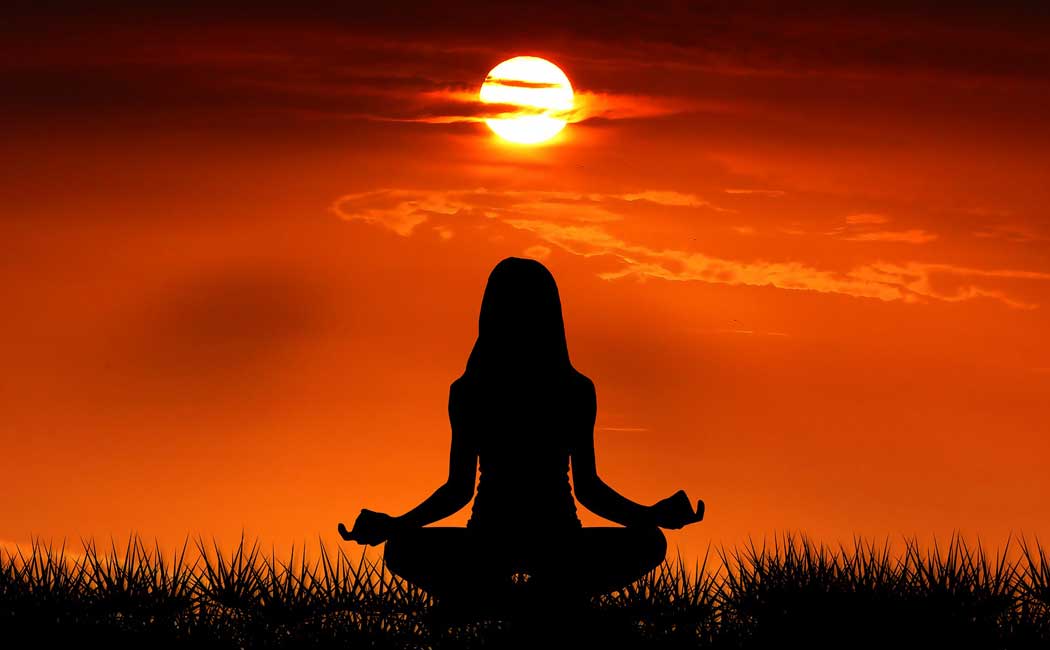Silhouette of a woman meditating