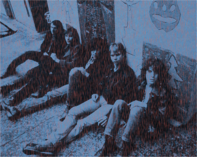 Five band members sitting on floor of hallway with dark blue filter