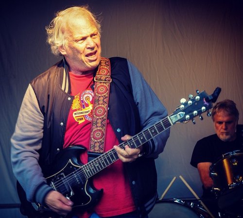 Old Barry playing electric guitar with red shirt and letterman's jacket
