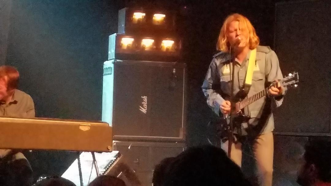 Ty Segall singing and playing his guitar during a performance