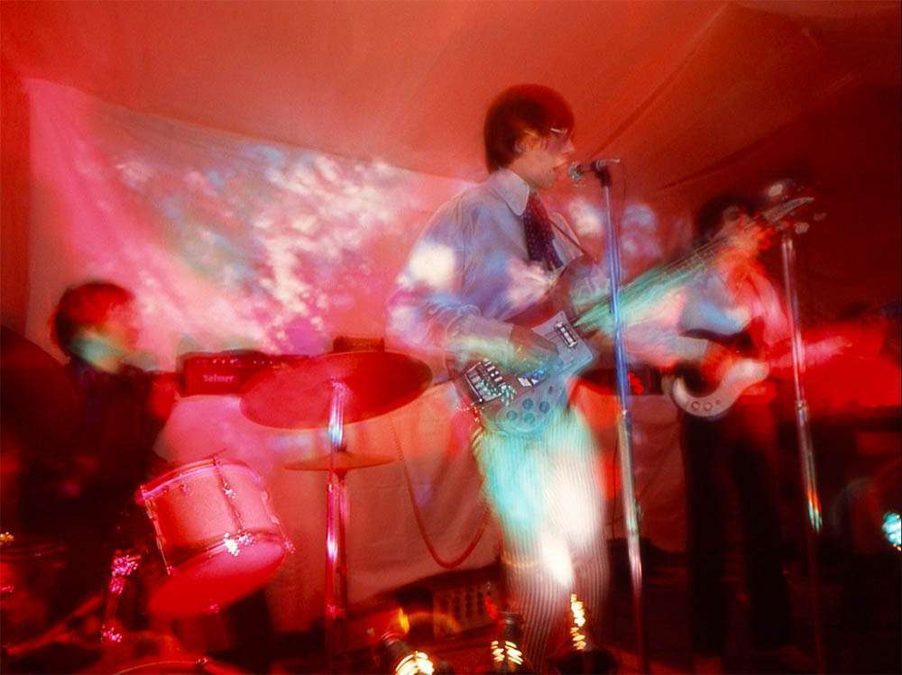 Pink Floyd performing onstage in 1966 with psychedelic lighting