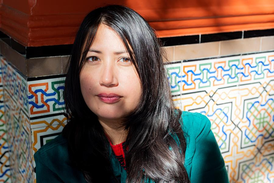 Young Guamese woman with long black hair in green blouse with shadow across her face