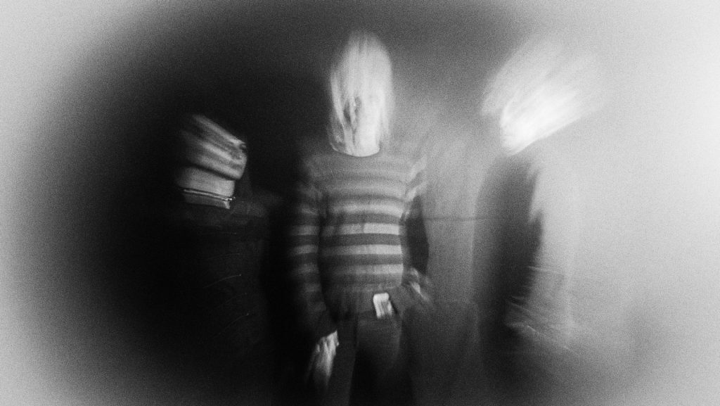 Blurred black and white photo of the three band members of Bebaloncar