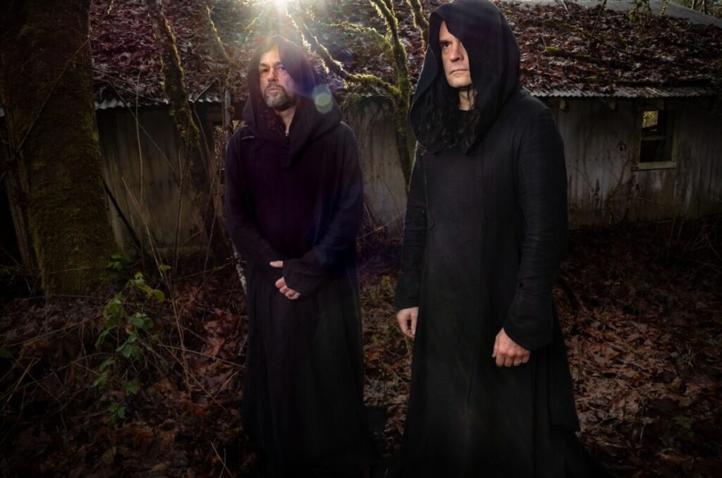 Two white men in black hooded robes standing