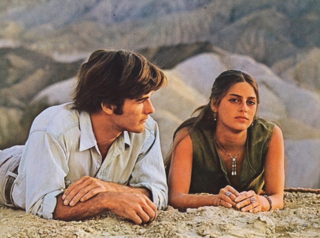 The antagonists of Zabriskie Point laying in the sand.