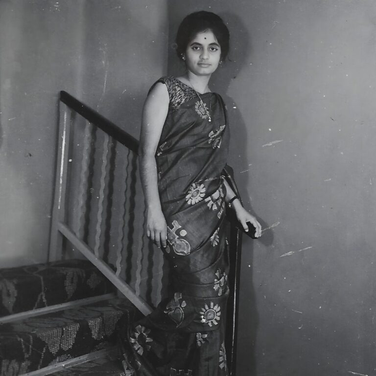 Photo of a young Indian woman in dress on a staircase