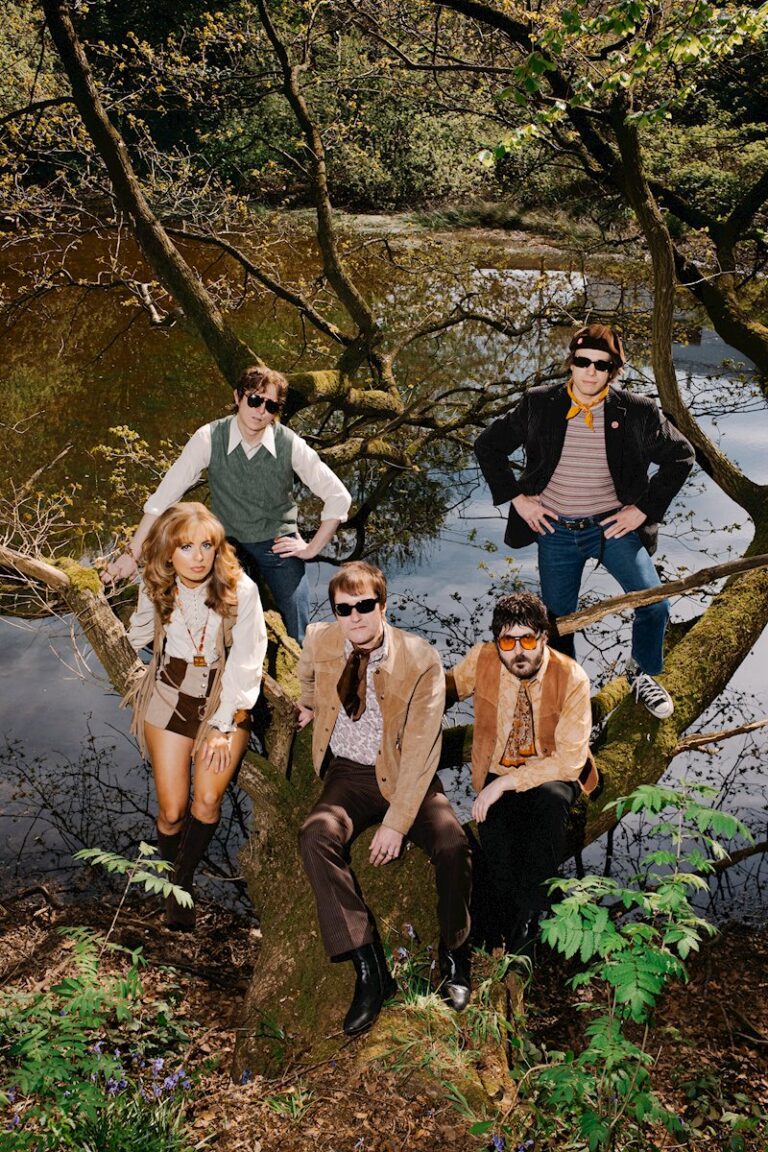 Aerial photo of the five members of The Crystal Teardrop sitting in a tree above a river